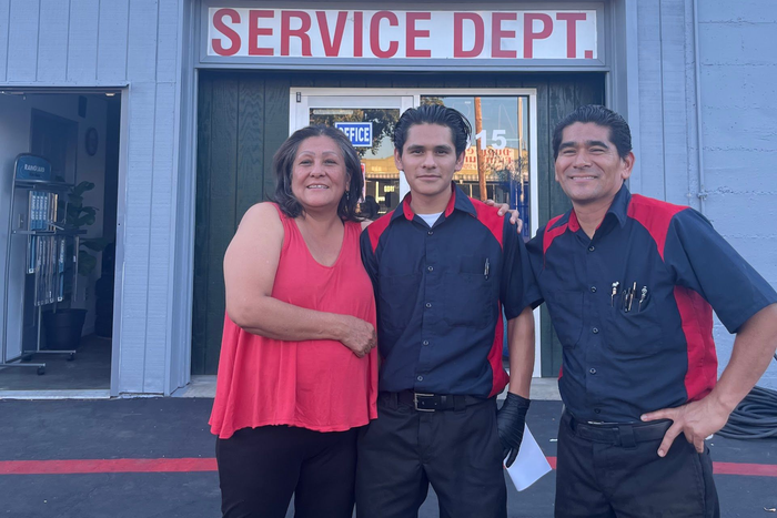 Three people smiling in front of a