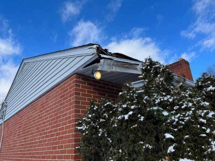 A brick house with a white siding and a light on the side of it.