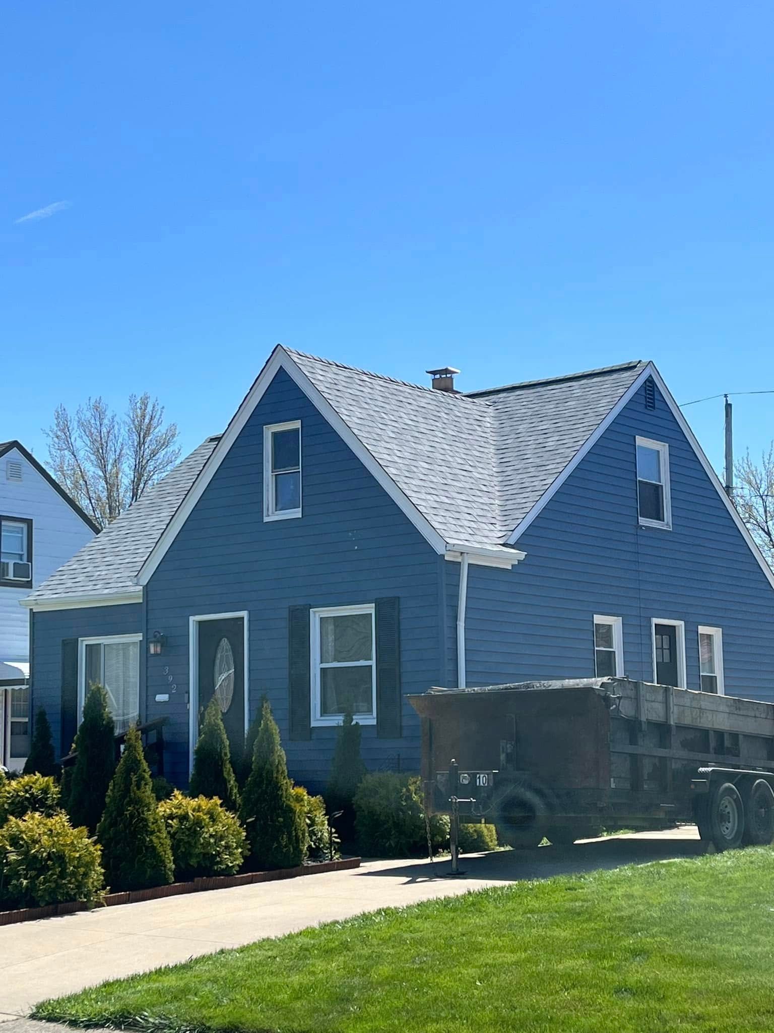 A blue house with a truck parked in front of it