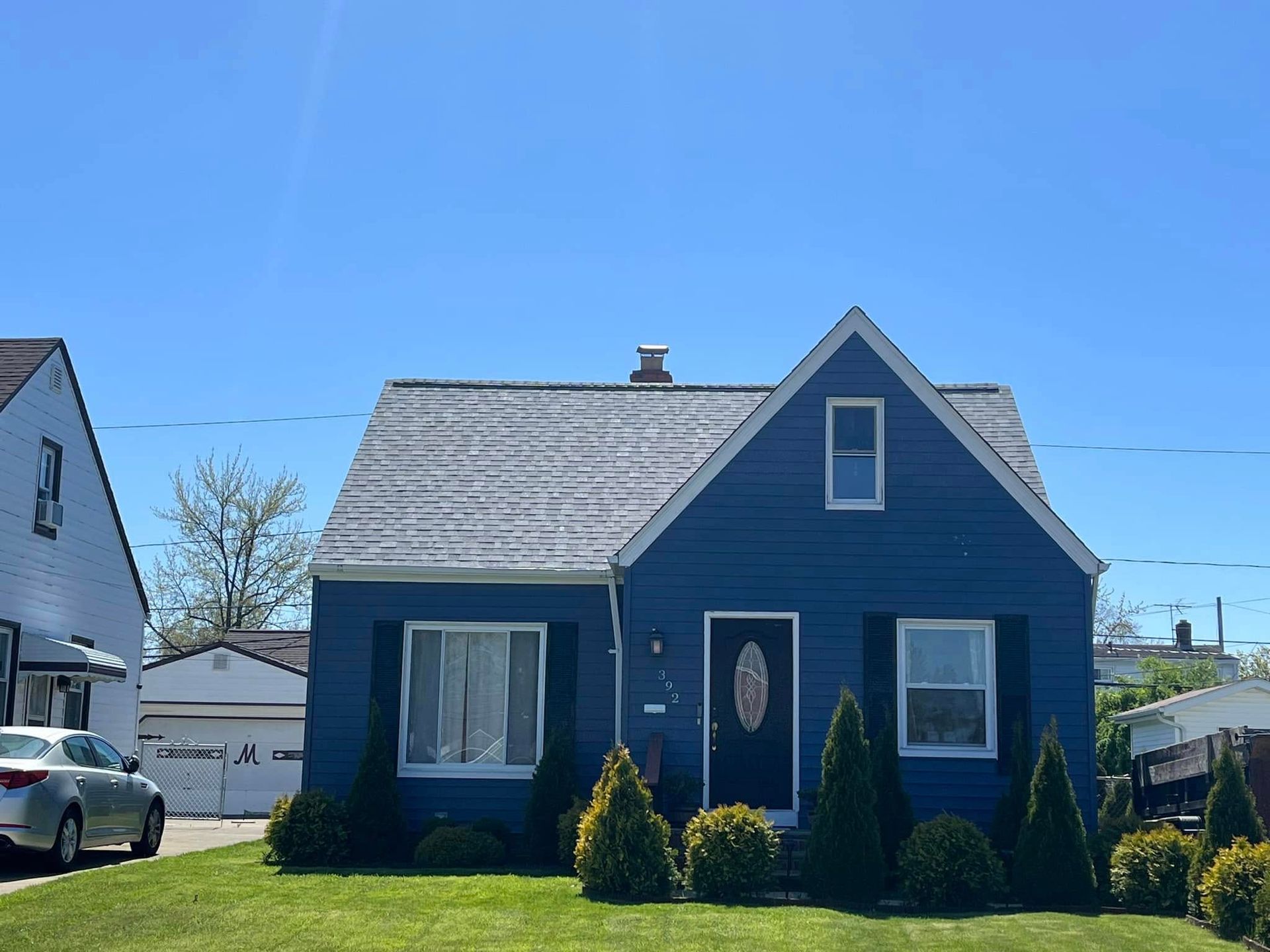 A blue house with a car parked in front of it