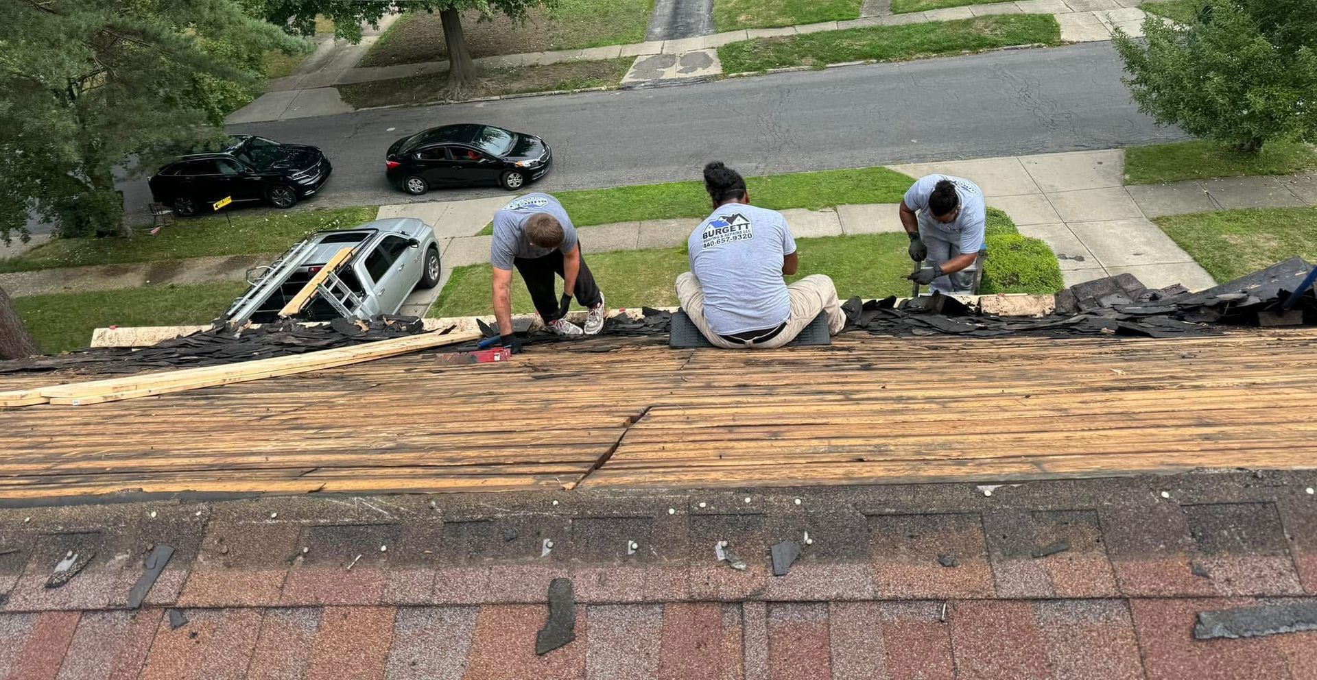 A man is working on a roof with a drill.