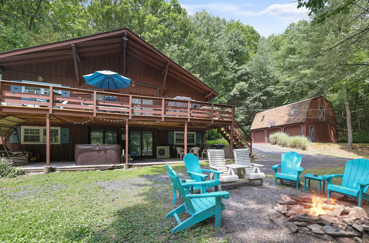 A large wooden house with a fire pit in front of it.
