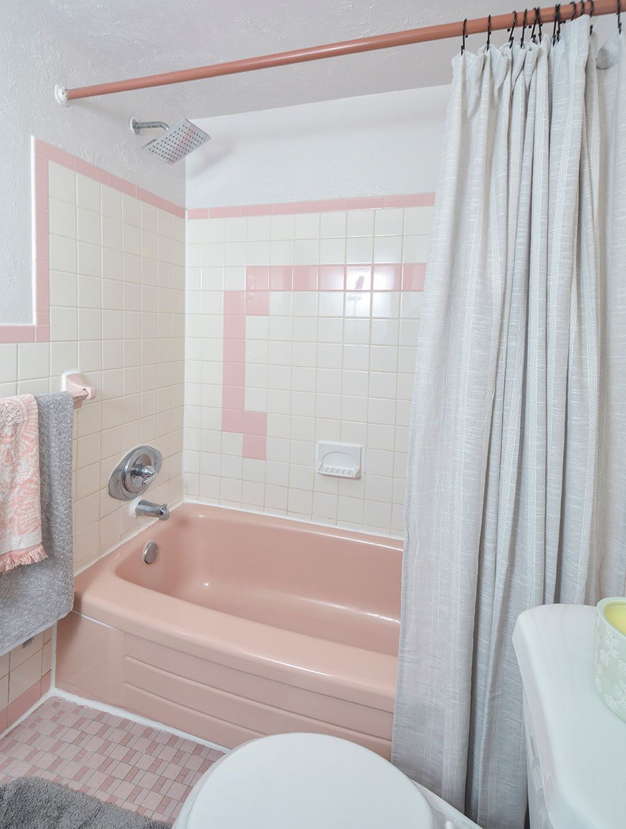 Pink-tiled bathroom with a pink tub, tile walls, and a gray shower curtain.
