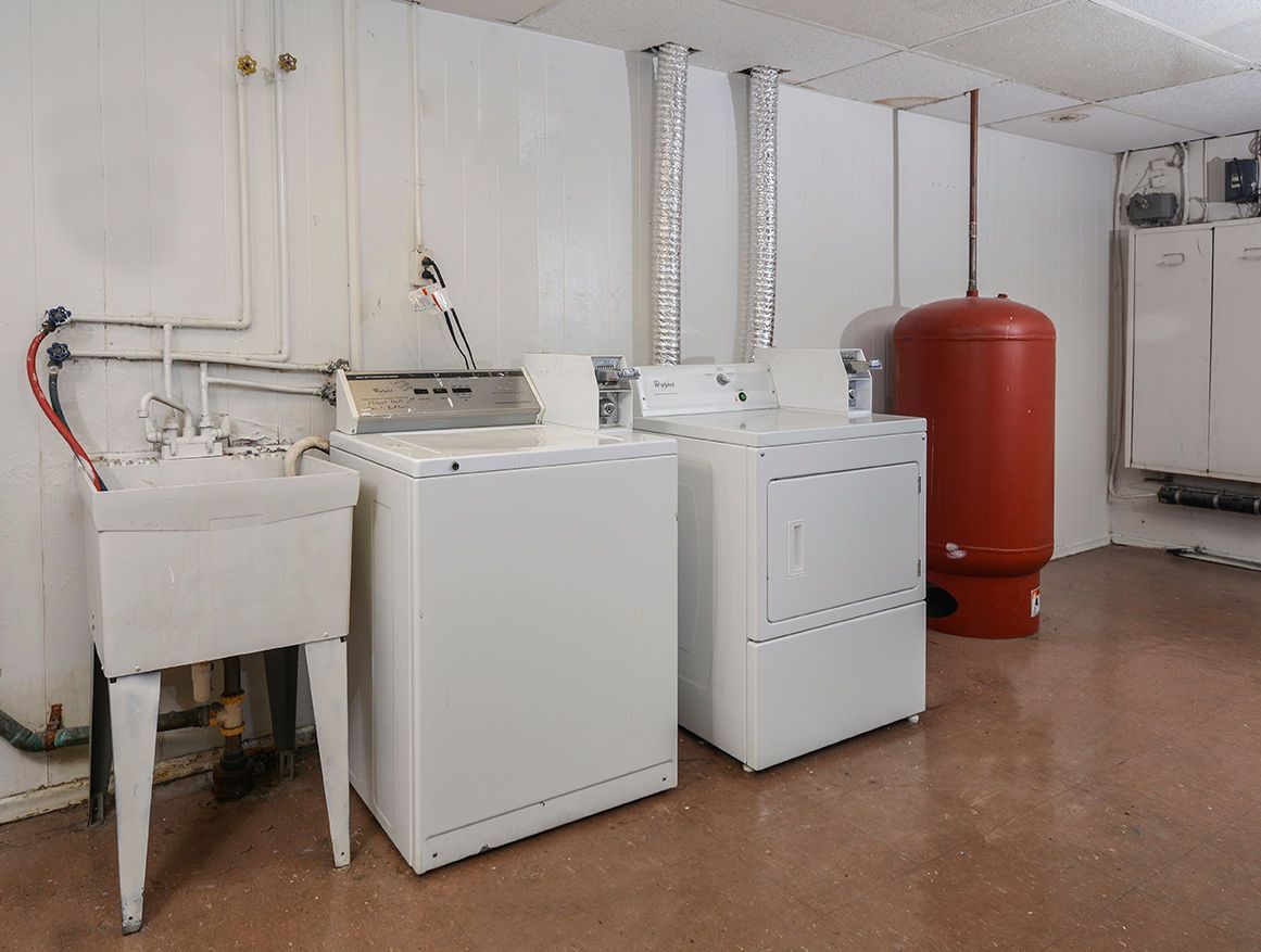 Common laundry room with a washer, dryer, utility sink, and red water heater.