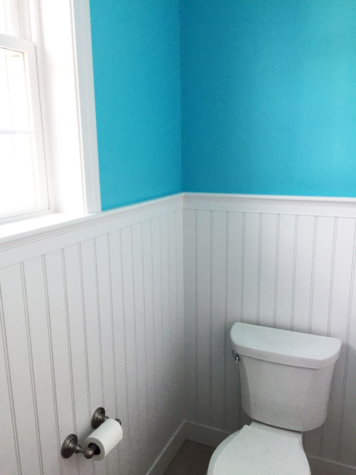 toilet with white and blue wall