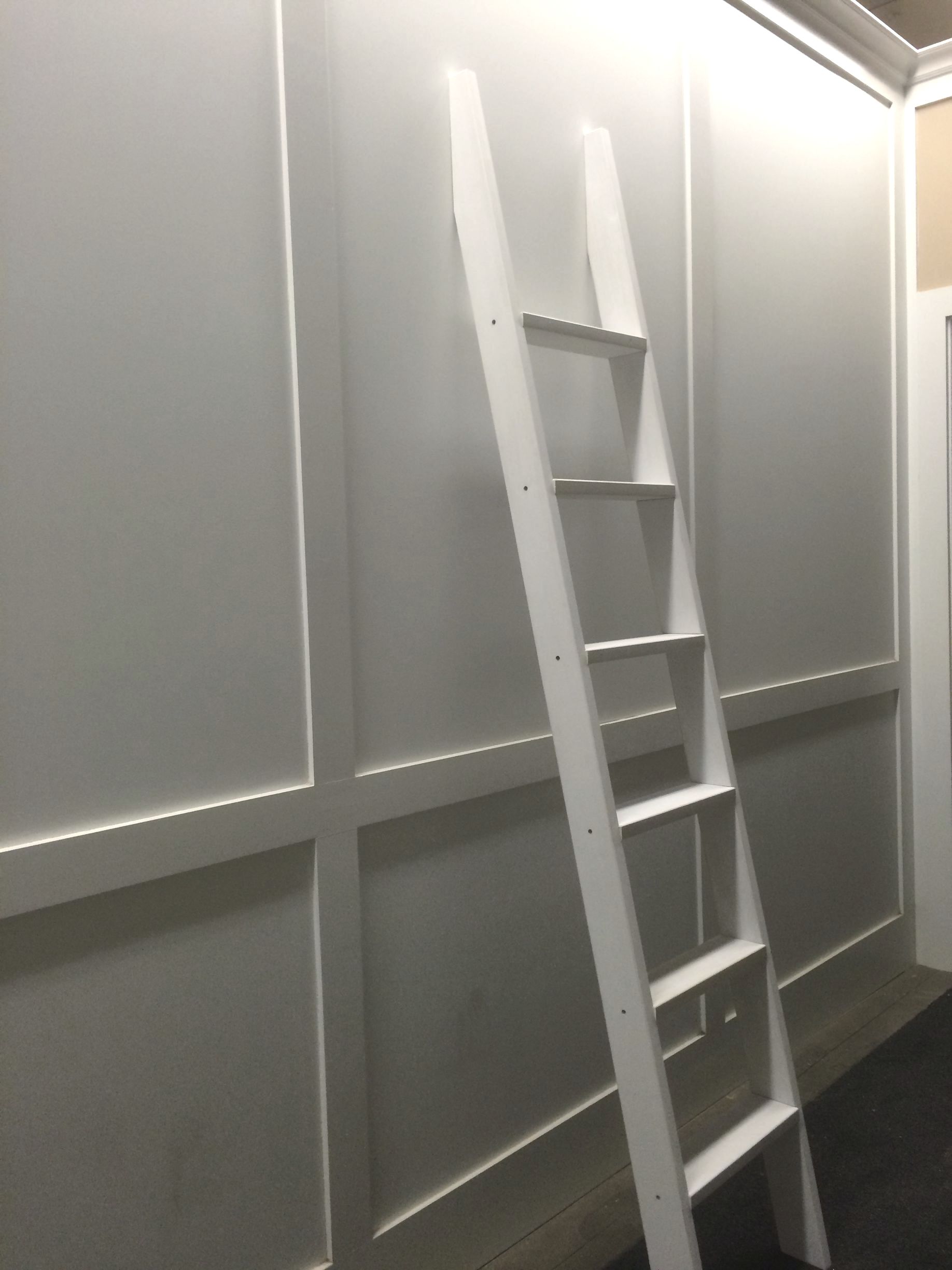 white ladder against a wall