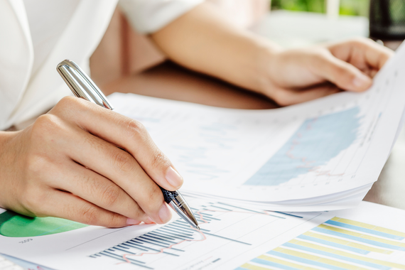 A bride and groom are kissing under a bridge.