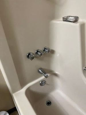 A white bathtub with chrome faucets in a bathroom.