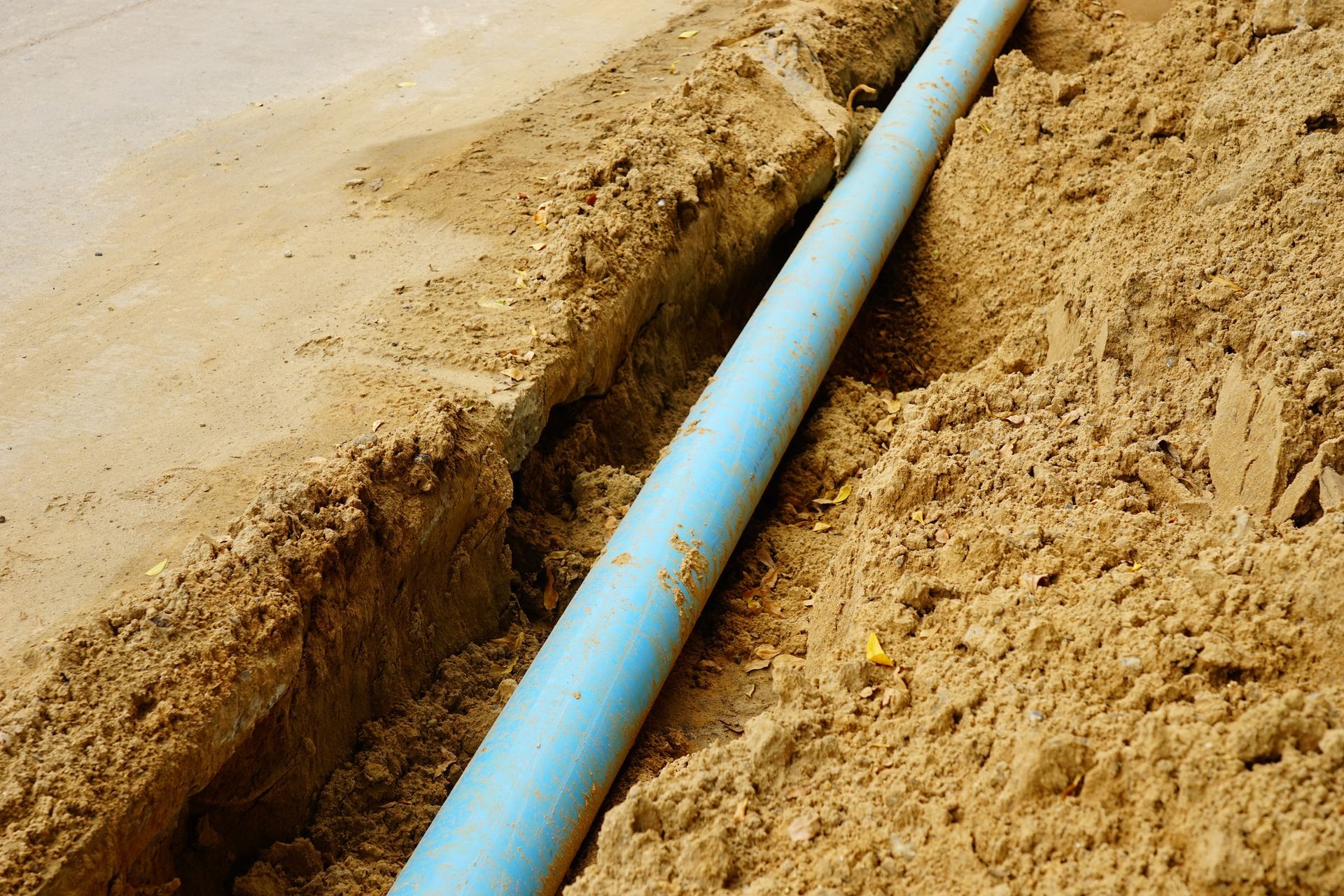 Long blue plastic sewer pipes on road.
