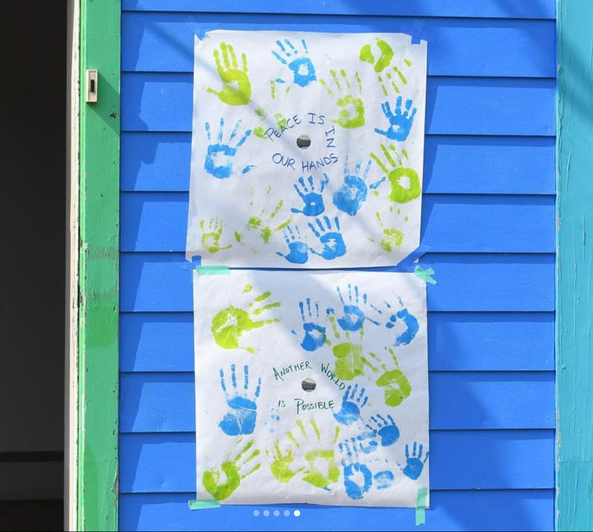 Two white posters with blue and green handprints on a blue wall. Text on posters: 