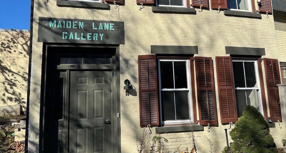 Maiden Lane Gallery entrance, tan building with brown shutters and sign, dark wooden door.