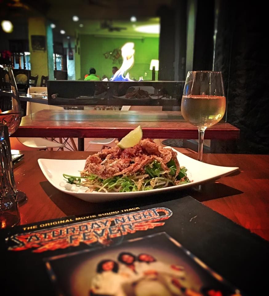 A Plate of Food Sits on A Table Next to A Book Titled Saturday Night Fever — The Point Cafe Restaurant in Port Macquarie, NSW