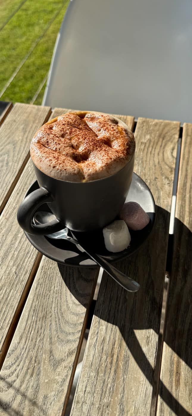 A Cup of Hot Chocolate with Marshmallows on A Saucer on A Wooden Table — The Point Cafe Restaurant in Port Macquarie, NSW
