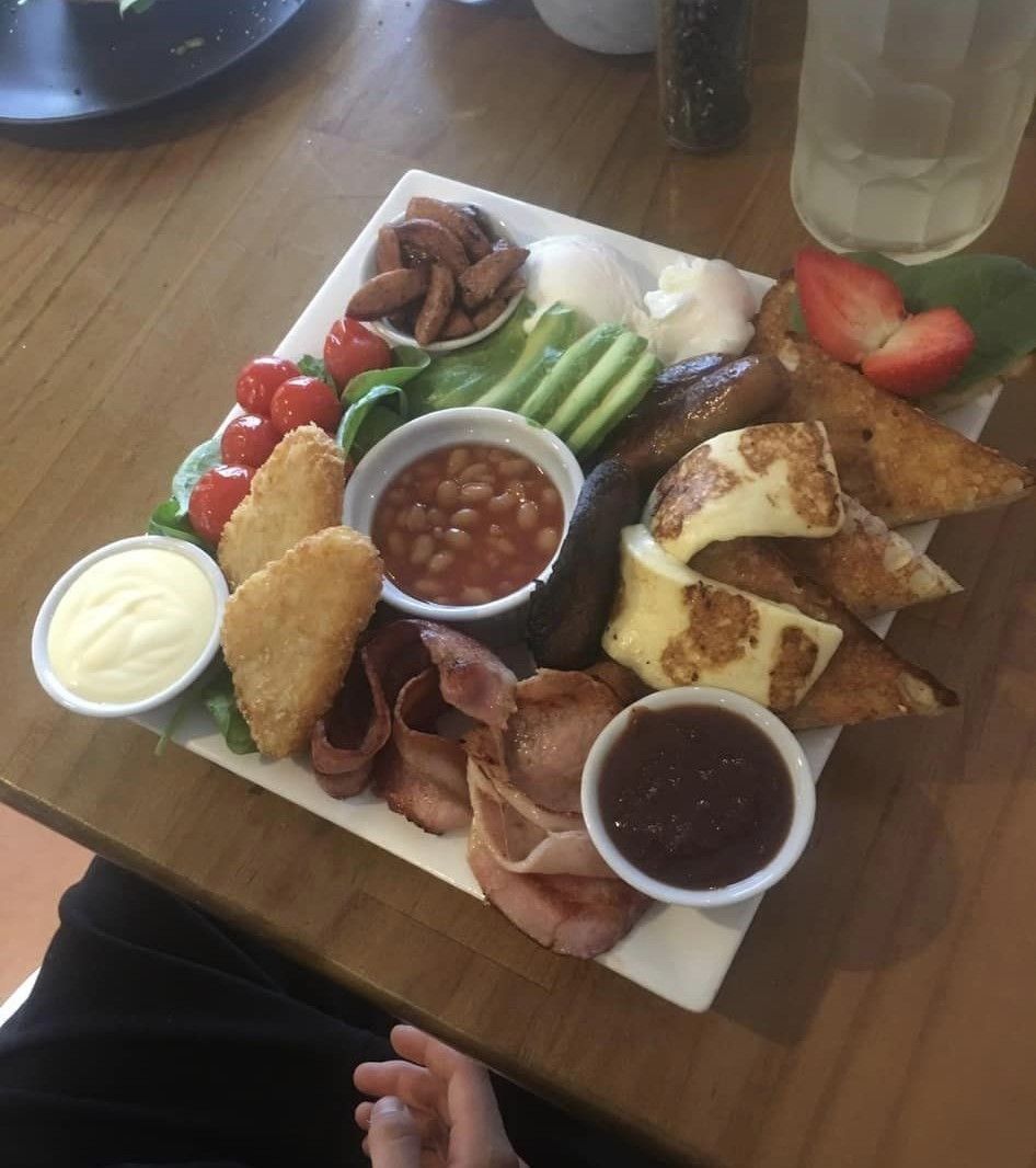 A Plate of Food Is on A Wooden Table — The Point Cafe Restaurant in Port Macquarie, NSW