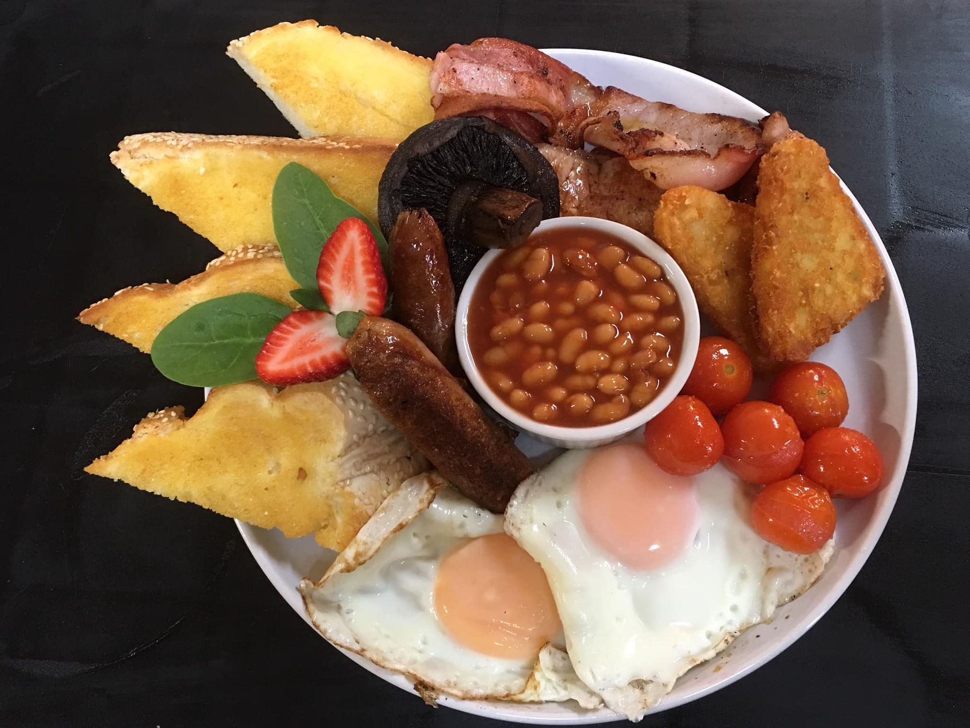 A Plate of Food with Eggs, Bacon, Beans, Tomatoes and Toast on A Table — The Point Cafe Restaurant in Port Macquarie, NSW