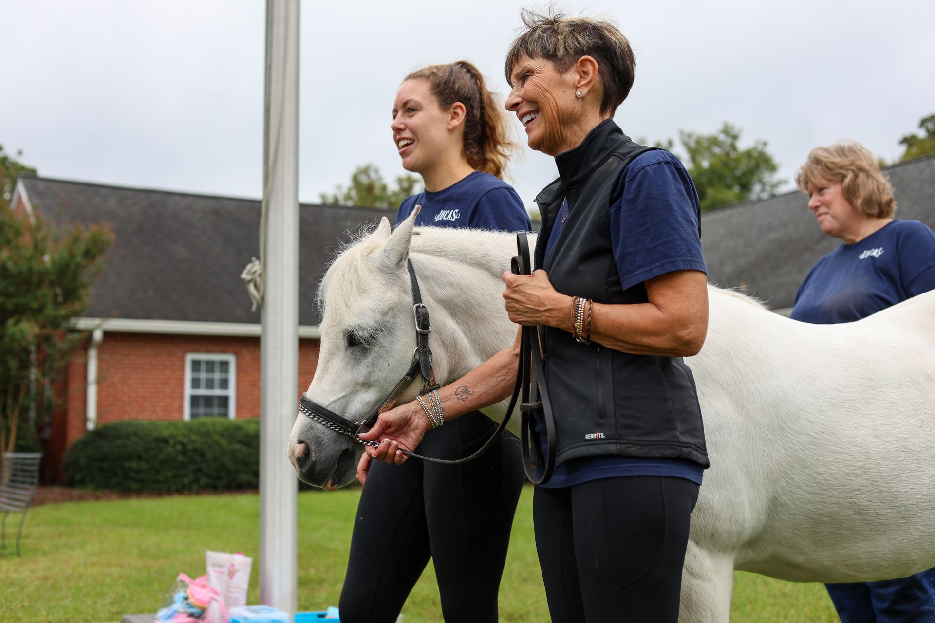 Riding Instructors holding the reigns of a white horse