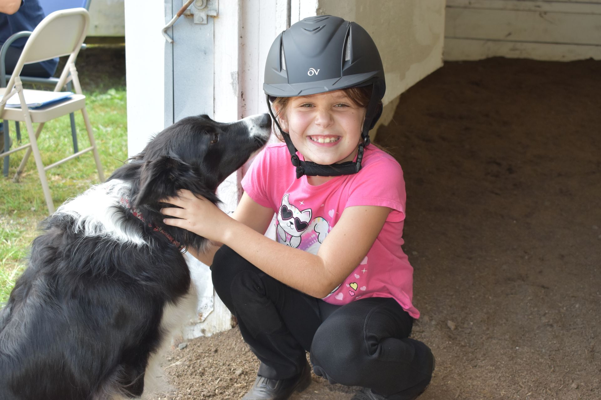 A girl petting a dog at the riding academy