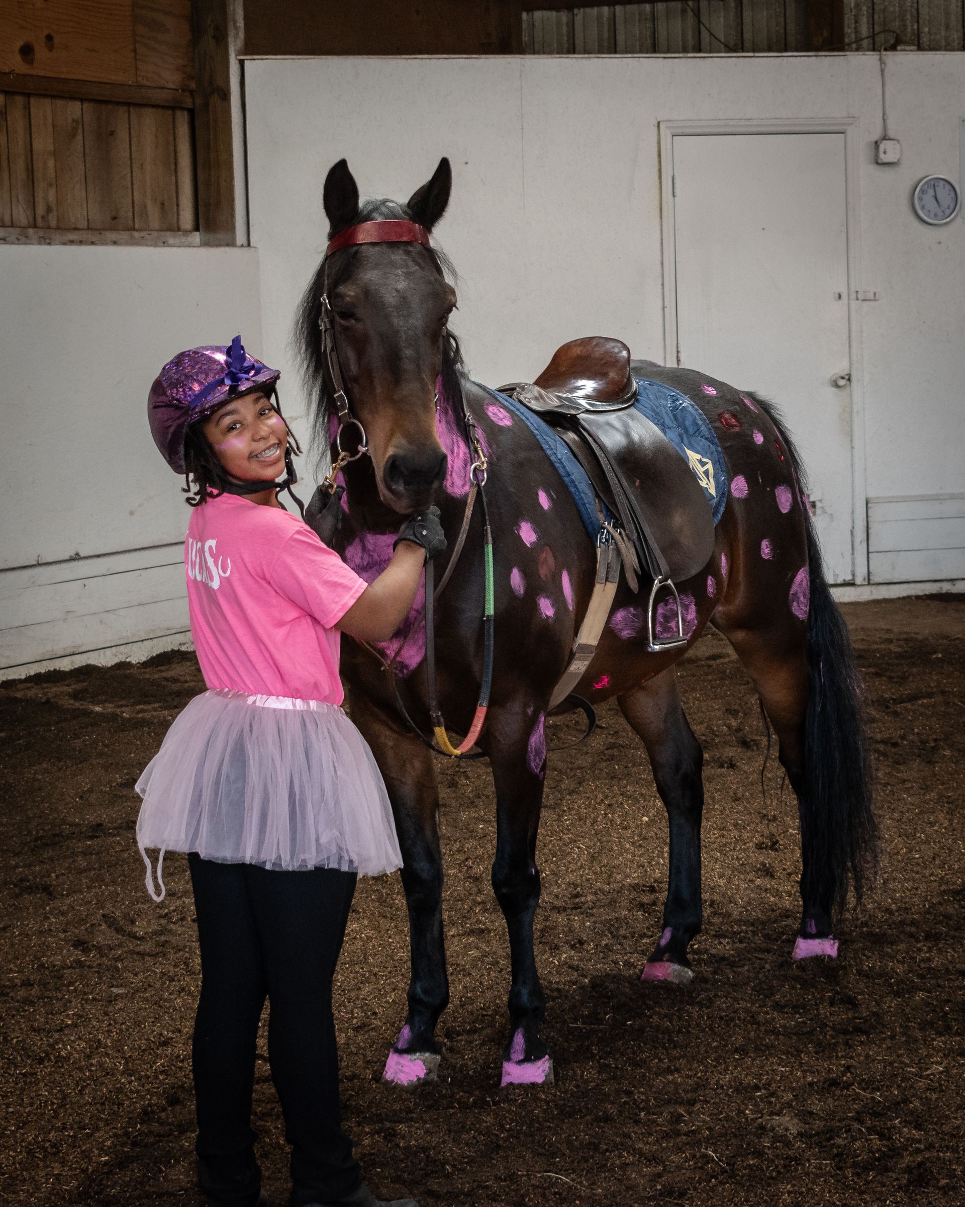 a group of preschool children lined up next to the horse and the instructors. 