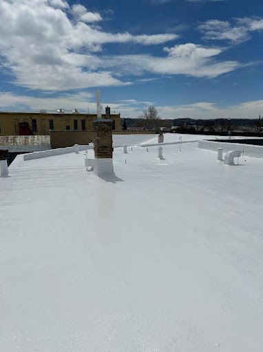 A white roof with a chimney on top of it.