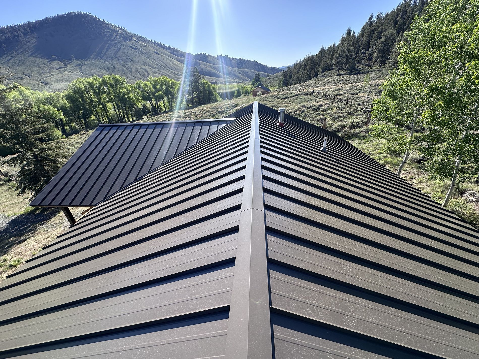 A black roof with a mountain in the background