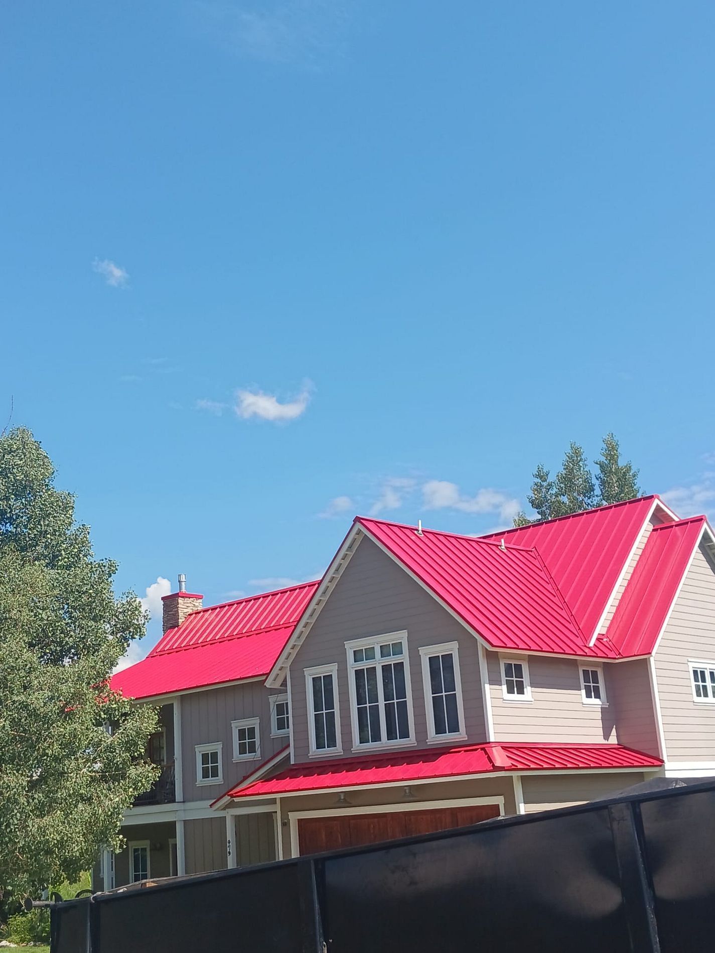 A house with a red roof and a blue sky in the background