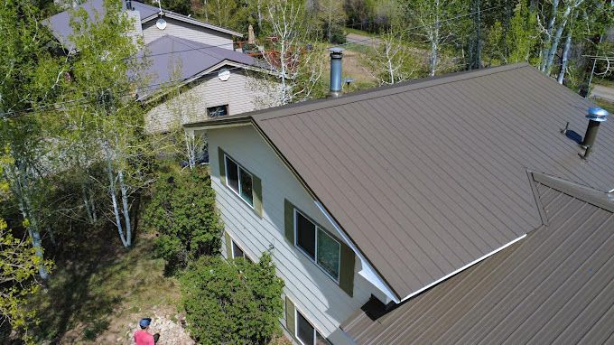An aerial view of a house with a brown roof