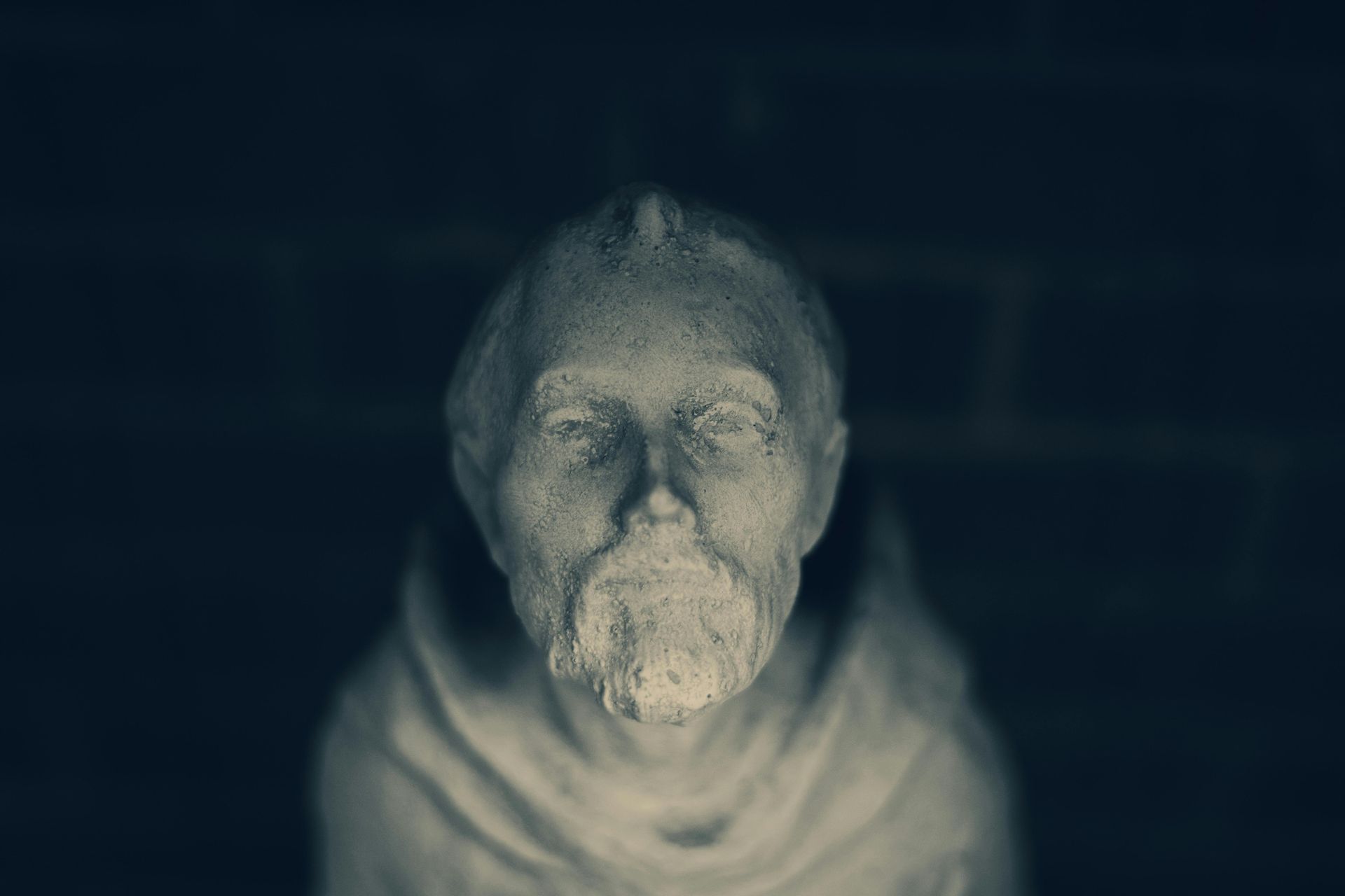 A statue of a man with a beard has his eyes closed