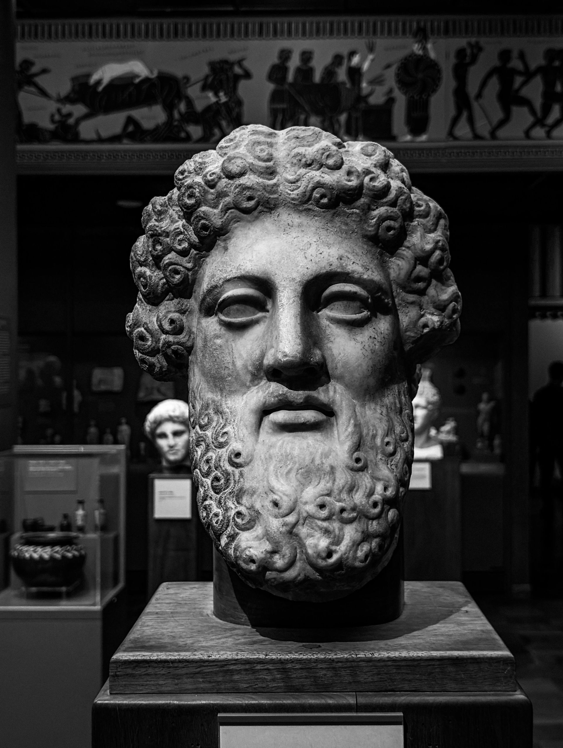A black and white photo of a statue of a man with curly hair and a beard.