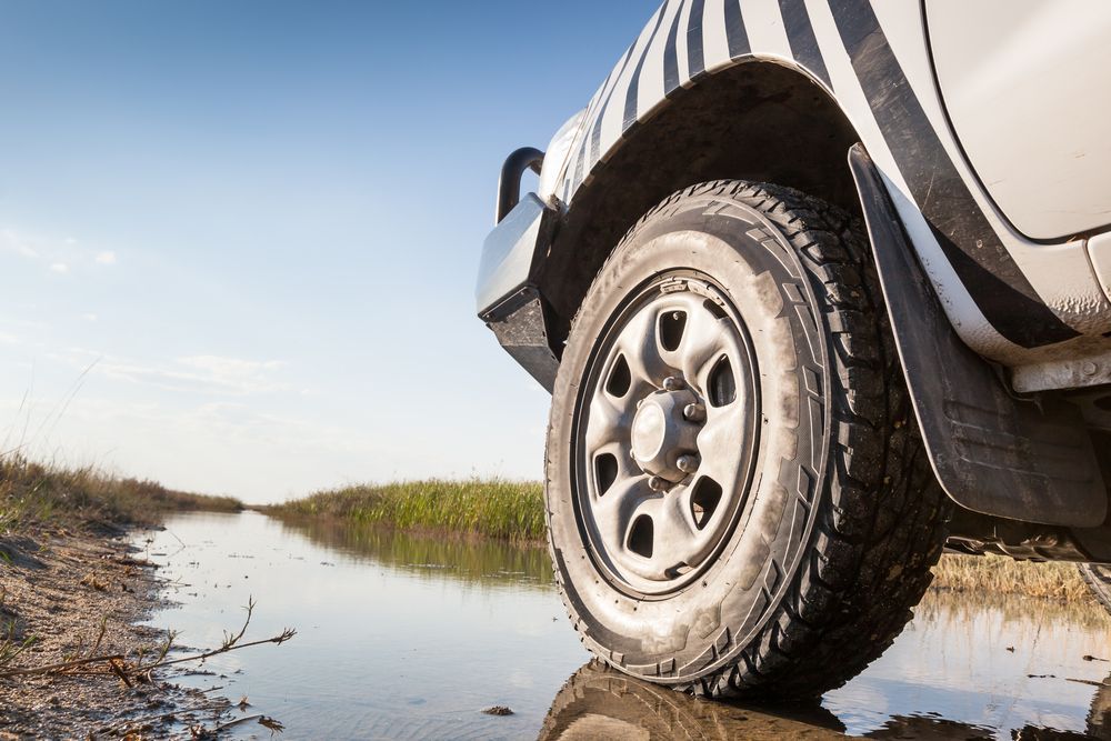 A White Truck Is Driving Through A Muddy River — Maitland 4WD Centre In Singleton, NSW