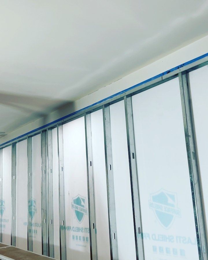 A row of sliding glass doors with a shield on them