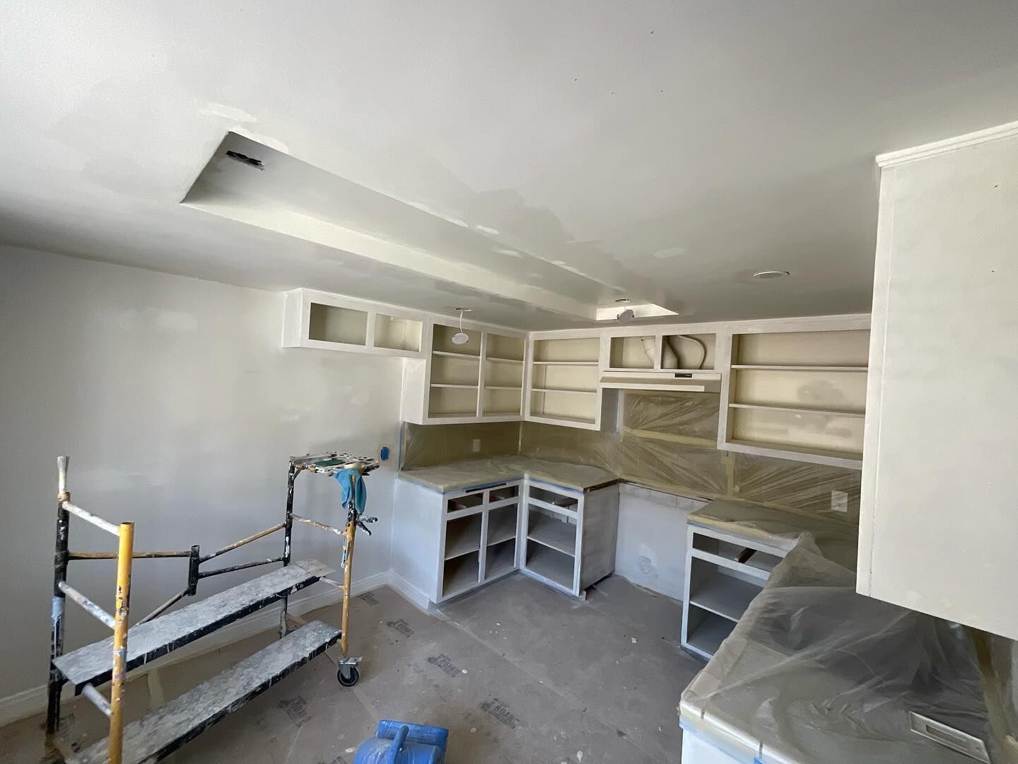 A kitchen under construction with a ladder and scaffolding.