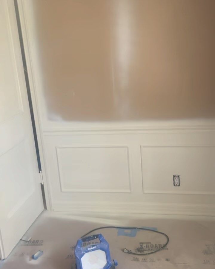 A room with white walls and a blue vacuum cleaner on the floor.