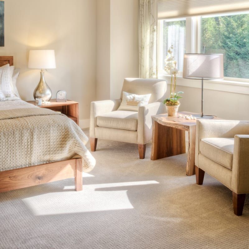 A bedroom with a bed two chairs and a table