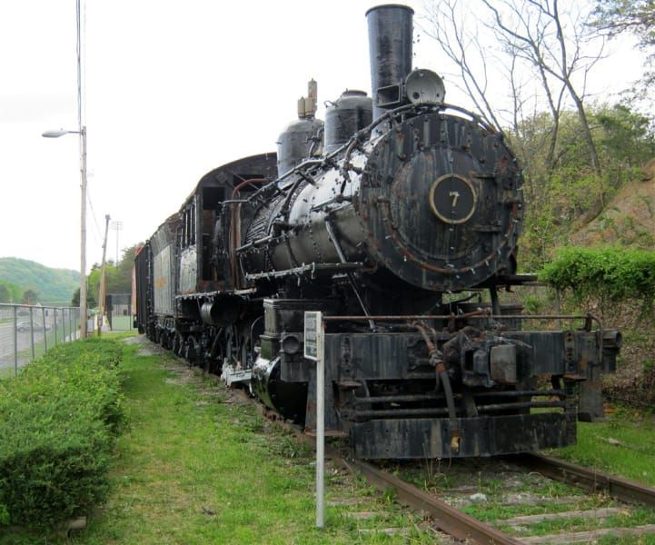 A train with the number 7 on the front of it is on the tracks.