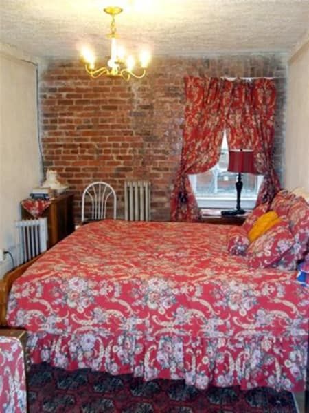 A bedroom with a bed and a brick wall
