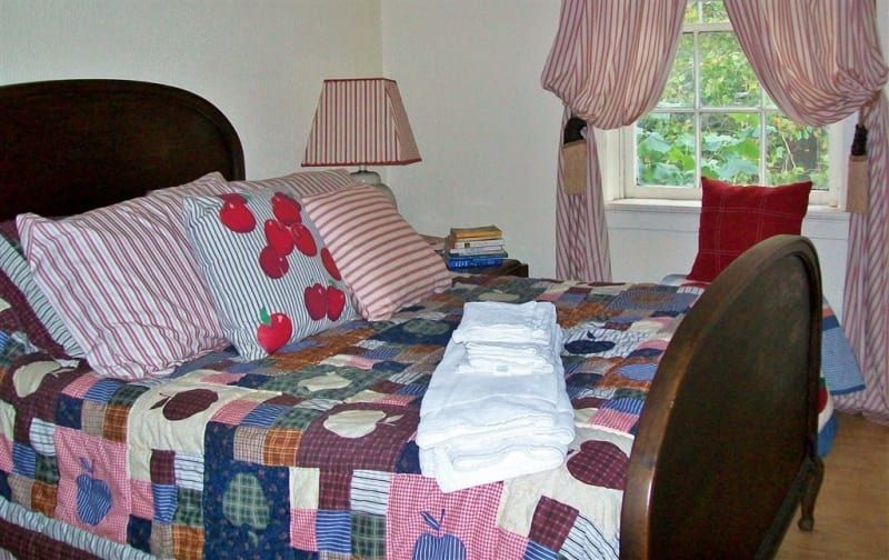 A bed with a quilt and pillows in a bedroom