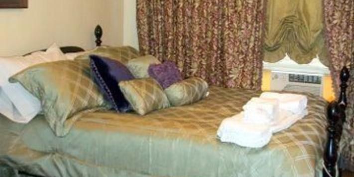 A bed with a lot of pillows and towels on it in a hotel room.
