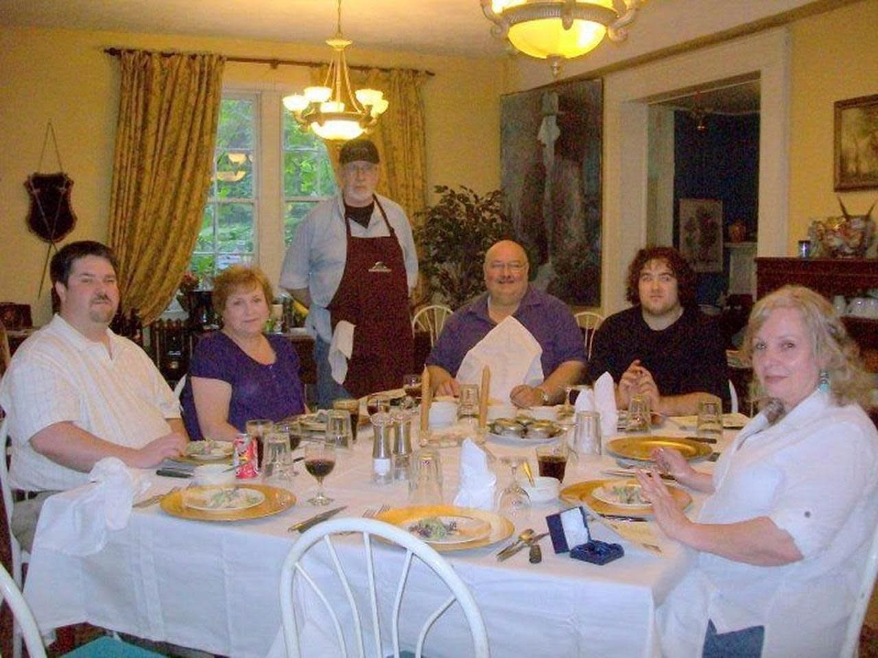 A group of people are sitting at a table with plates of food
