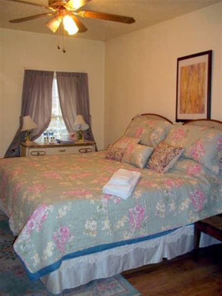 A bedroom with a bed and a ceiling fan