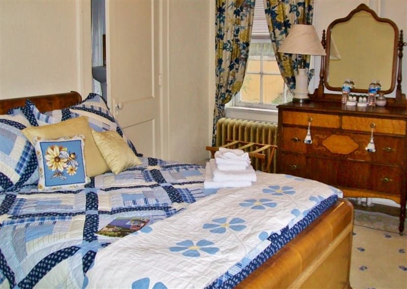 A bedroom with a bed dresser and mirror