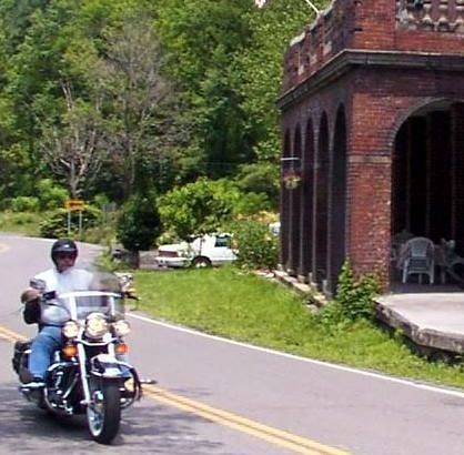 A man is riding a motorcycle down a road.