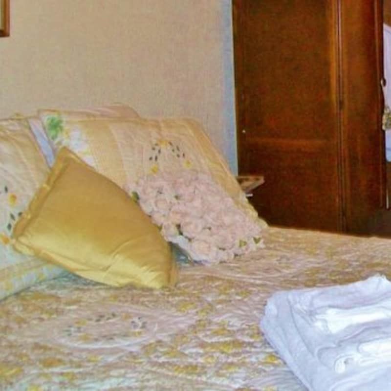 A bed with pillows and towels on it in a bedroom.