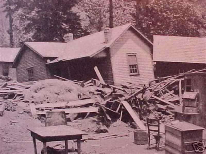 A black and white photo of a house being demolished