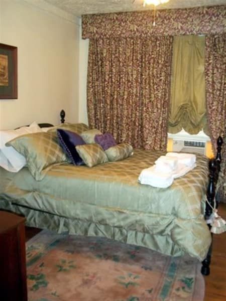 A bedroom with a king size bed and a rug