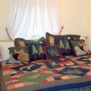 A bed with a quilt and pillows on it in a bedroom.
