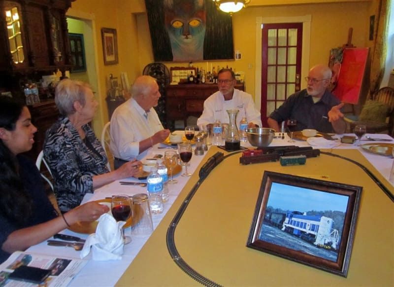 A group of people are sitting around a table with a picture of a train on it