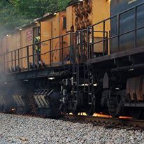 A train is going down the tracks with smoke coming out of it.