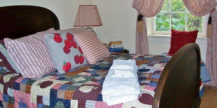 A bed with a quilt and pillows in a bedroom