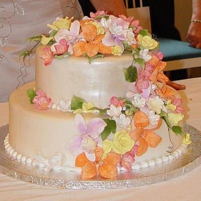 A wedding cake with flowers on it is on a table
