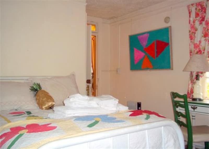 A bedroom with a pineapple pillow on the bed